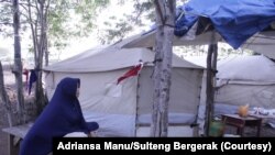 Seorang ibu yang duduk di luar tenda darurat di sekitar bundaran STQ Kota Palu, Sulawesi Tengah, April 2020. (Foto: Adriansa Manu/Sulteng Bergerak)