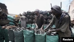 Somali businessmen arrange charcoal inside bags along a street near the main Baraka market in Mogadishu, March 27, 2012.