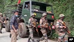 This image from video shows Indian army soldiers arriving at the site after an army helicopter carrying India's Chief of Defense Staff Bipin Rawat crashed near Coonoor, Tamil Nadu state, India, Dec. 8, 2021.