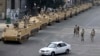 FILE - Egyptian army soldiers take their positions on top and next to their armored vehicles to guard an entrance of Tahrir Square, in Cairo, August 2013.