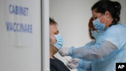 Seorang petugas medis memberikan suntikan booster vaksin COVID-19 buatan Pfizer-BioNTech kepada seorang warga di Bukarest, Rumania (28/9).