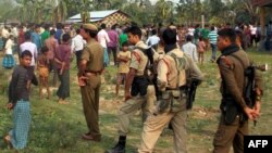 Indian security personnel are pictured as villagers look on following an overnight attack by suspected tribal militants on a village in Kokrajhar, India's northeastern state of Assam, on May 2, 2014.