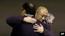 Ông Kenneth Bae (giữa), người đã bị giam cầm ở Bắc Triều Tiên từ năm 2012, đến khu căn cứ liên hợp Lewis-McChord ngày 8 tháng 11 năm 2014 sau khi được trả tự do trong một nhiệm vụ tối mật.