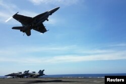An F18 fighter takes off from the deck of the USS Theodore Roosevelt while transiting the South China Sea, April 10, 2018.