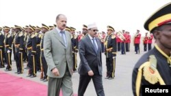 FILE - Eritrea's President Isaias Afwerki, left, walks beside Somalia's President Mohamed Abdullahi Mohamed during a welcoming ceremony upon his arrival for a three-day visit to Eritrea, in Asmara, Eritrea, July 28, 2018.