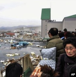 Des Japonais qui constatent l'ampleur des dégâts causés par le séisme et le tsunami