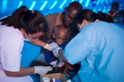 Petugas kesehatan mengambil sampel darah seorang anak Papua di rumah sakit sementara yang menangani pasien campak dan gizi buruk di Agats, ibu kota Kabupaten Asmat pada 25 Januari 2018. (Foto: AFP/Bay Ismoyo)