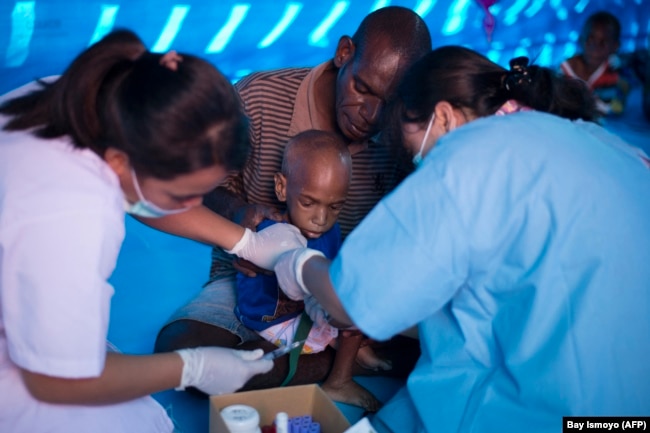 Petugas kesehatan mengambil sampel darah seorang anak Papua di rumah sakit sementara yang menangani pasien campak dan gizi buruk di Agats, ibu kota Kabupaten Asmat pada 25 Januari 2018. (Foto: AFP/Bay Ismoyo)