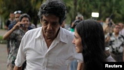 FILE - Cuba's best-known dissident, blogger Yoani Sanchez, walks with her husband Reinaldo Escobar outside Havana's Jose Marti International Airport, May 30, 2013.