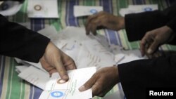 Officials count ballots after polls closed in Zagazig, about 62.5 km northeast of Cairo on Dec.15, 2012. 