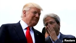 Italian Prime Minister Paolo Gentiloni speaks to U.S. President Donald Trump during a family photo at the G7 Summit expanded session in Taormina, Sicily, Italy, May 27, 2017. 