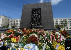 People lay wreaths and flowers during state ceremonies in homage to the victims and fighters of the 1943 Warsaw Ghetto Uprising, in Warsaw, April 19, 2018.