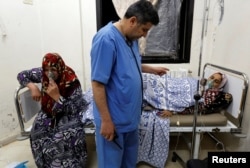 Women, affected by what activists say was a gas attack, receive treatment inside a makeshift hospital in Kfar Zeita village in the central province of Hama, Syria, May 22, 2014.