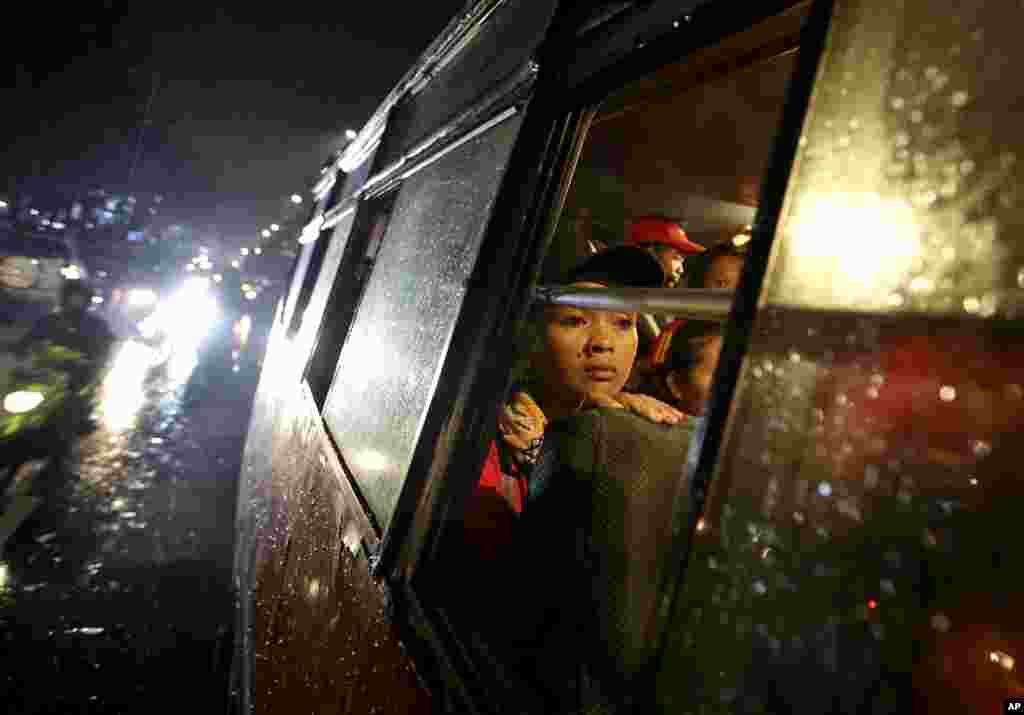 1일 인도네시아 자카르타 시청 앞에서 임금 인상을 요구하는 시위가 한창인 가운데, 시위 대원들이 비를 피해 버스 안으로 피신했다.