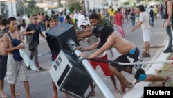 Người biểu tình Brazil phá đổ một cột đèn giao thông trong cuộc đụng độ với cảnh sát chống bạo động gần Estadio Castelao, Fortaleza, ngày 19/6/2013.