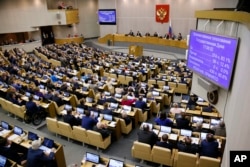 FILE - Russian lawmakers are seen during a vote at the State Duma, the Lower House of the Russian Parliament, in Moscow, Russia, May 8, 2018.