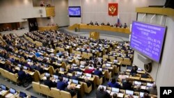 FILE - Russian lawmakers are seen during a vote at the State Duma, the lower house of the Russian parliament, in Moscow, May 8, 2018.