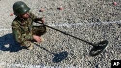 An Afghan soldier uses a mine detector. 