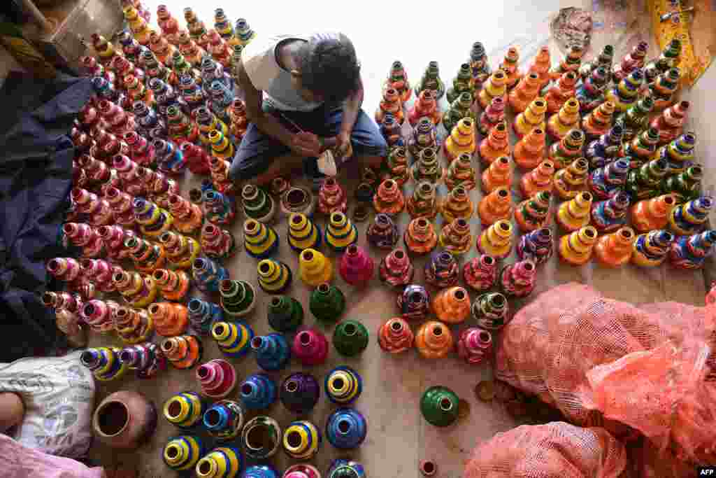 An artist decorates earthenware oil pots or 'diyas' at his workshop on the outskirts of Hyderabad, India, ahead of the Diwali festival of lights. Diyas, which are lit and placed around the home, are in heavy demand during the festival which marks the victory of good over evil.
