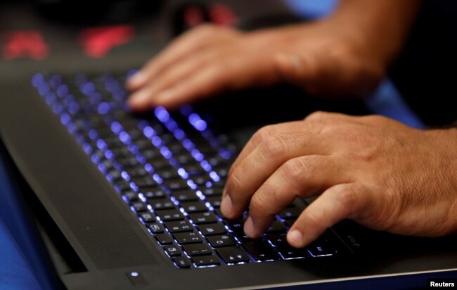 FILE - A man types into a keyboard during the Def Con hacker convention in Las Vegas, Nevada, on July 29, 2017.