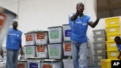 Staff organize ballot boxes and election materials as they are brought in from polling stations after counting at a National Election Commission warehouse in Monrovia, Liberia, October 12, 2011.