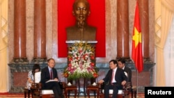 World Bank President Jim Young Kim (front L) and Vietnam's President Truong Tan Sang (front R) meet in front of a statue of late Vietnamese revolutionary leader Ho Chi Minh at the Presidential Palace in Hanoi, July 17, 2014.