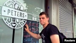 FILE - Peter Garratt, one of the sons of Canadian couple Kevin and Julia Dawn Garratt, who are being investigated in China for threatening national security, stands outside his parents' coffee shop as he talks to Reuters journalists in Dandong, Liaoning province, China, Aug. 6, 2014.