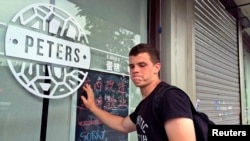 Peter Garratt, one of the sons of Canadian couple Kevin and Julia Dawn Garratt, who are being investigated in China for threatening national security, stands outside his parents' coffee shop as he talks to Reuters journalists in Dandong, Liaoning province