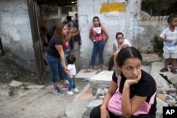 In this Oct. 31, 2018 photo, relatives wait for a bus to transport them home.