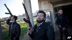 FILE - Free Syrian Army fighters look at a Syrian Army jet, not pictured, in Fafeen village, north of Aleppo province, Syria. A spokesman for the High Negotiations Committee said representatives plan to start arriving in Geneva on Friday.