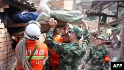 Rescuers carry a paralyzed elderly person from his damaged house in the city of Ya'an. 