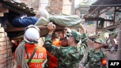 Les secouristes portant une personne âgée et handicapée depuis sa maison endommagée dans le canton de Qingren dans le comté de Lushan, après le puissant séisme - 20 avril 2013