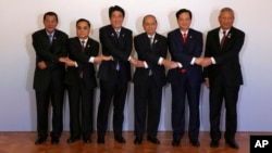 Japanese Prime Minister Shinzo Abe, third from left, join hands with leaders of the Mekong region nations.