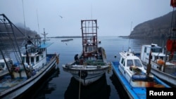 FILE - A fisherman sits on his boat in a small port on the island of Baengnyeong.