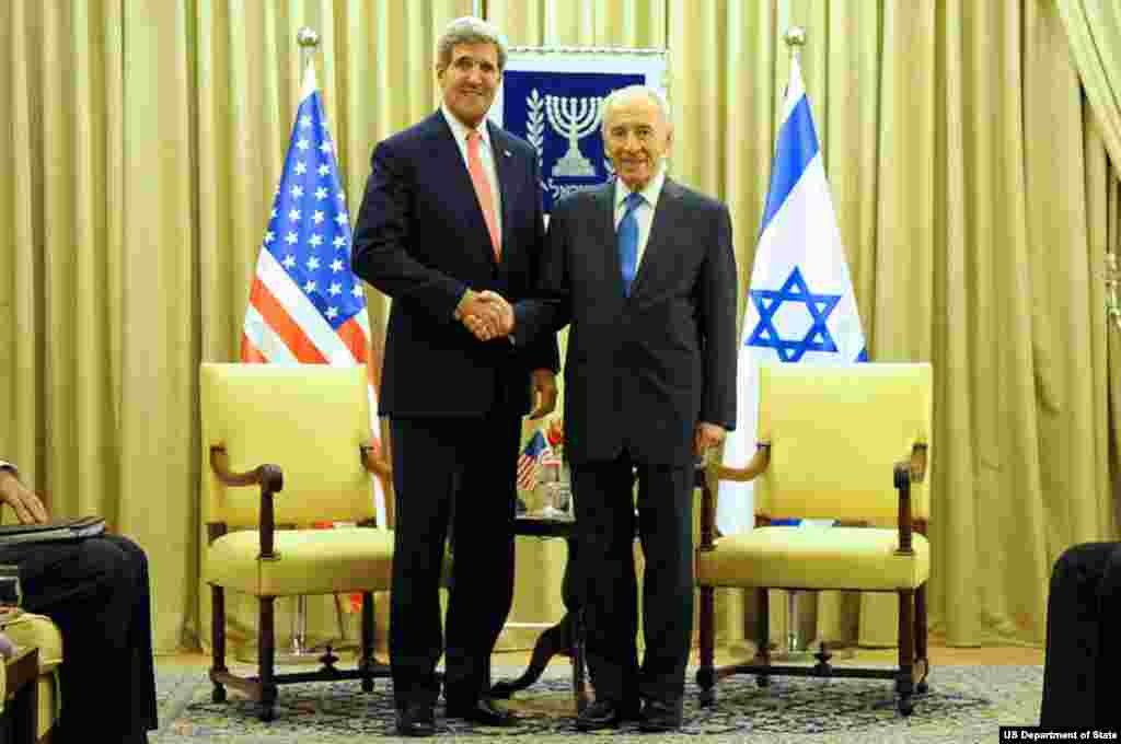 U.S. Secretary of State John Kerry and Israeli President Shimon Peres shake hands for reporters before making statements about Middle East peace at outset of a meeting in Jerusalem on November 6, 2013.