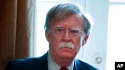 FILE - National Security Adviser John Bolton listens as President Donald Trump speaks during a cabinet meeting at the White House in Washington, April 9, 2018.