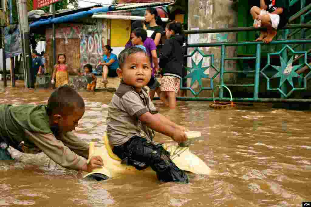 Children play in flood waters after torrential rains in Kampung Melayu, South Jakarta, Indonesia, January 17, 2013. (K. Lamb/VOA)