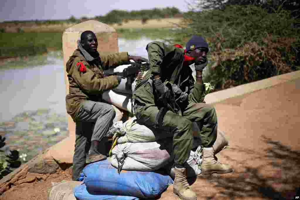 Malian soldiers man a bridge at the entrance of Gao, northern Mali where a suicide bomber on a motorcycle killed himself attempting to blow up an army checkpoint, Feb. 8, 2013.