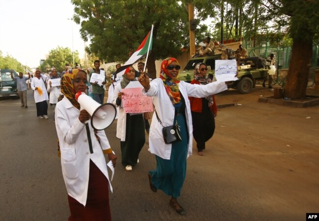 Sudanese medics shout slogans as they hold a rally in front of a hospital in the capital Khartoum on May 23, 2019.