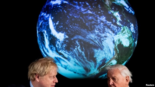 FILE - British Prime Minister Boris Johnson and David Attenborough speak with school children during a conference about the COP26 UN Climate Summit, at the Science Museum in London, Feb. 4, 2020. (Chris J Ratcliffe/Pool via Reuters)