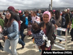 Members of the Central American migrants caravan arrive at the "El Chaparral" pedestrian crossing on their way to U.S. Customs and Border Patrol, at the U.S.-Mexico border in Tijuana, Mexico, April 29, 2018. (A. Martinez/VOA)