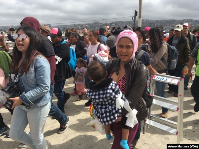 Members of the Central American migrants caravan arrive at the "El Chaparral" pedestrian crossing on their way to U.S. Customs and Border Patrol, at the U.S.-Mexico border in Tijuana, Mexico, April 29, 2018. (A. Martinez/VOA)