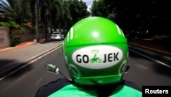 Pengemudi Go-Jek sedang mengendarai sepeda motor di Jakarta, 15 Desember 2017.