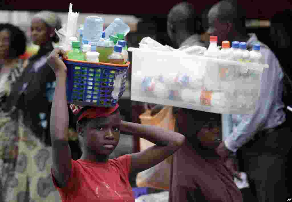 11일 나이지리아 라고스의 버스 정거장에서 음료를 파는 소녀.