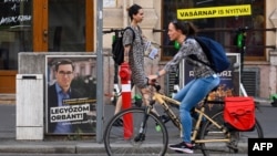 A cyclist rides past a campaign poster featuring Budapest Mayor and candidate for prime minister Gergely Karacsony of opposition party Parbeszed Magyarorszagert with the lettering reading 'I will defeat (Hungarian Prime Minister) Orban!' in Budapest on Sept. 15, 2021.