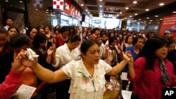 FILE - Overseas Filipino workers pray for the survivors of Typhoon Haiyan in the Philippines during a mass in Hong Kong, Nov. 17, 2013. 