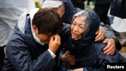 Family members of passengers missing on the overturned South Korean ferry Sewol react to the disaster.