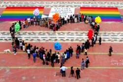 Anggota dan aktivis komunitas LGBTQ+ membentuk formasi berbentuk hati pada Hari Internasional Melawan Homofobia, Transfobia dan Biphobia di Mother Theresa Square, di tengah pandemi COVID-19 di Tirana, Albania, 17 Mei 2021. (REUTERS/Florion Goga)