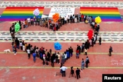 Anggota dan aktivis komunitas LGBTQ+ membentuk formasi berbentuk hati pada Hari Internasional Melawan Homofobia, Transfobia dan Biphobia di Mother Theresa Square, di tengah pandemi COVID-19 di Tirana, Albania, 17 Mei 2021. (REUTERS/Florion Goga)