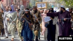 Pasukan Taliban berjalan di depan para demonstran dalam sebuah demo anti-Pakistan yang dilakukan di dekat kedutaan besar Pakistan di Kabul, Afghanistan, pada 7 September 2021. (Foto: Reuters/Stringer)